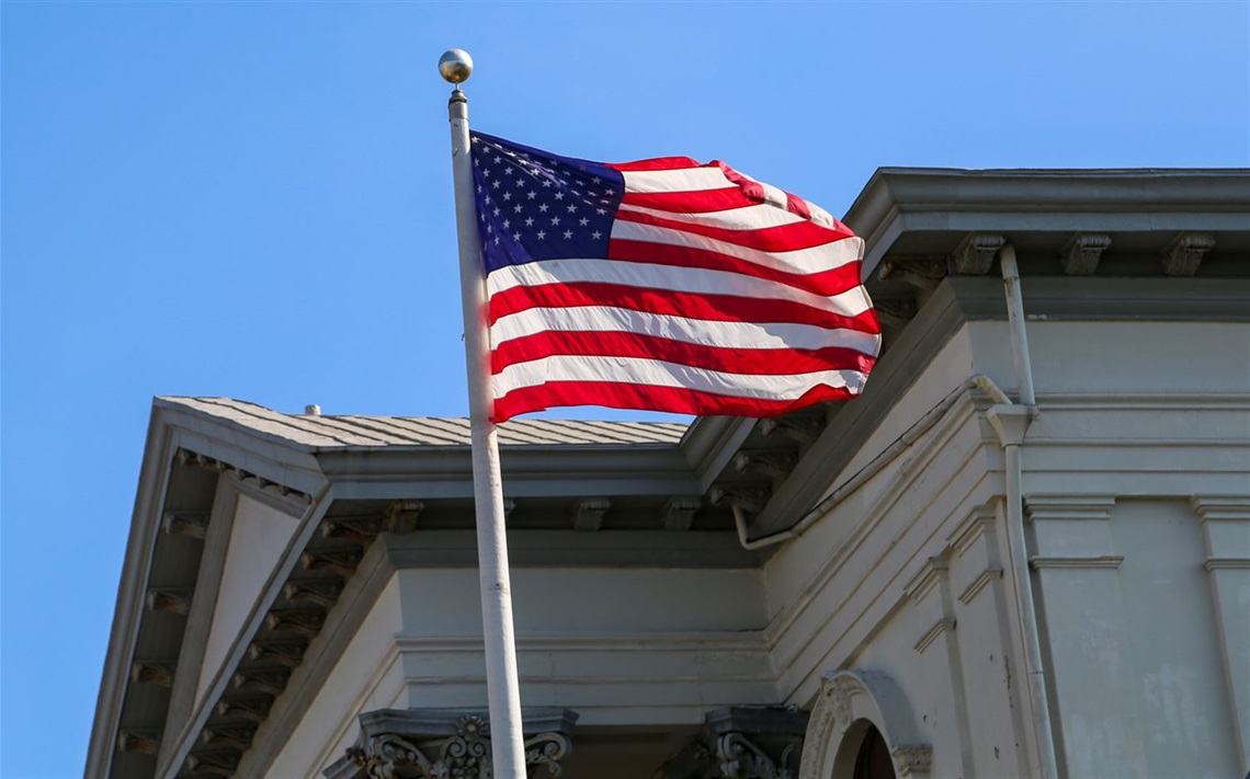 The United State flag waving next to City Hall