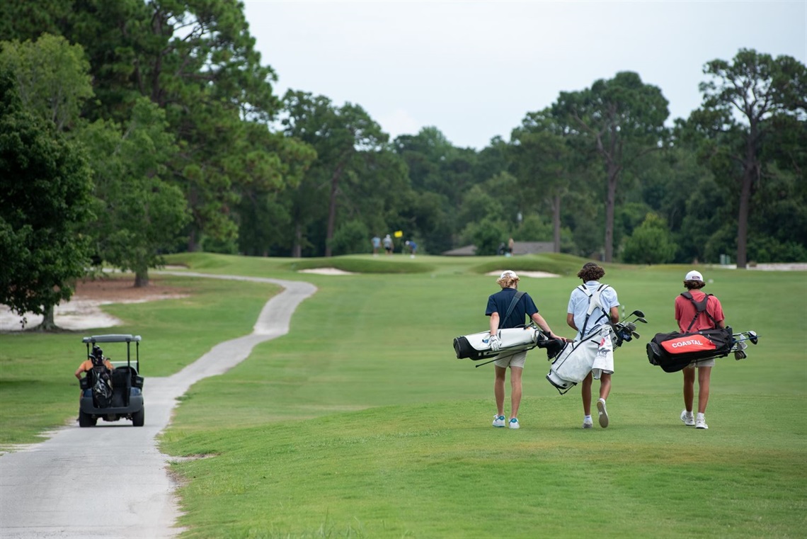 Three people walk along the Municipal Golf Course